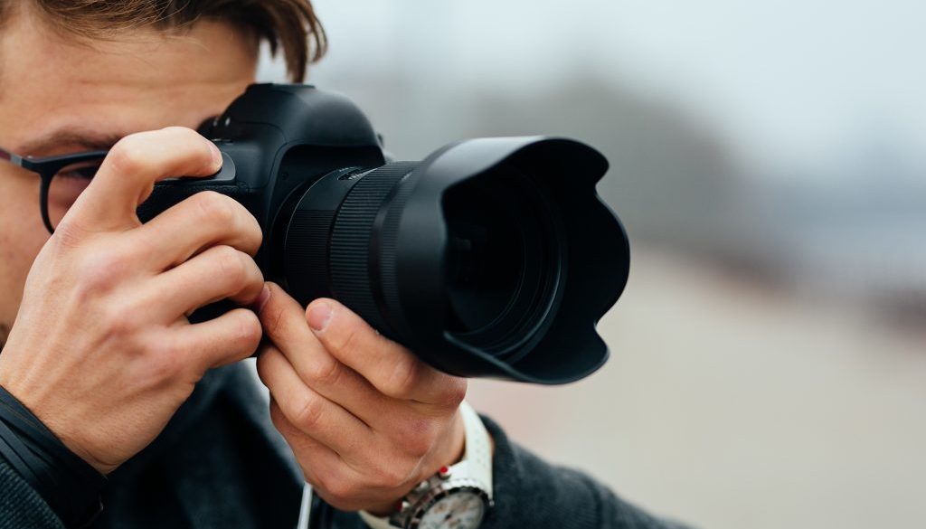 Close-up view of professional photographer taking picture outdoors